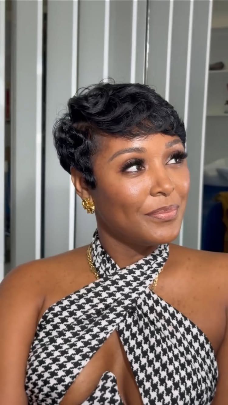 Woman with a short, softly waved dark pixie cut wearing a patterned halter top