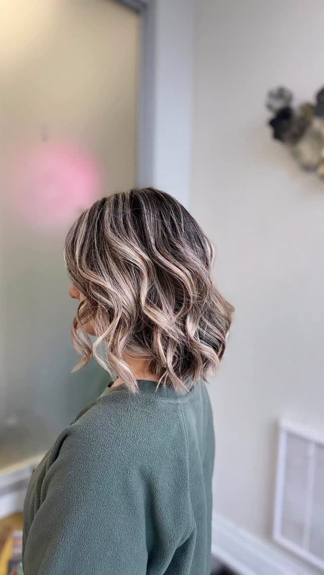 Shoulder-length highlighted waves with short layers and softly tousled ends