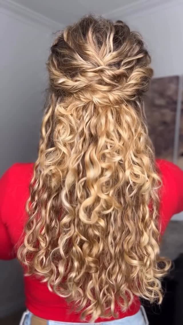Long blonde curls styled in a loose textured pinned half-up arrangement
