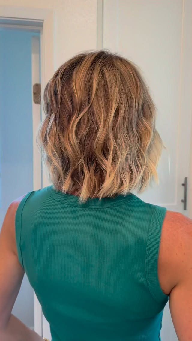 Tousled blonde bob with loose beachy bends and darker roots