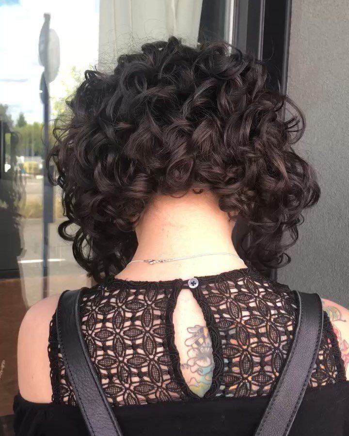Dark curly lob ending at the neck on a person seen from behind