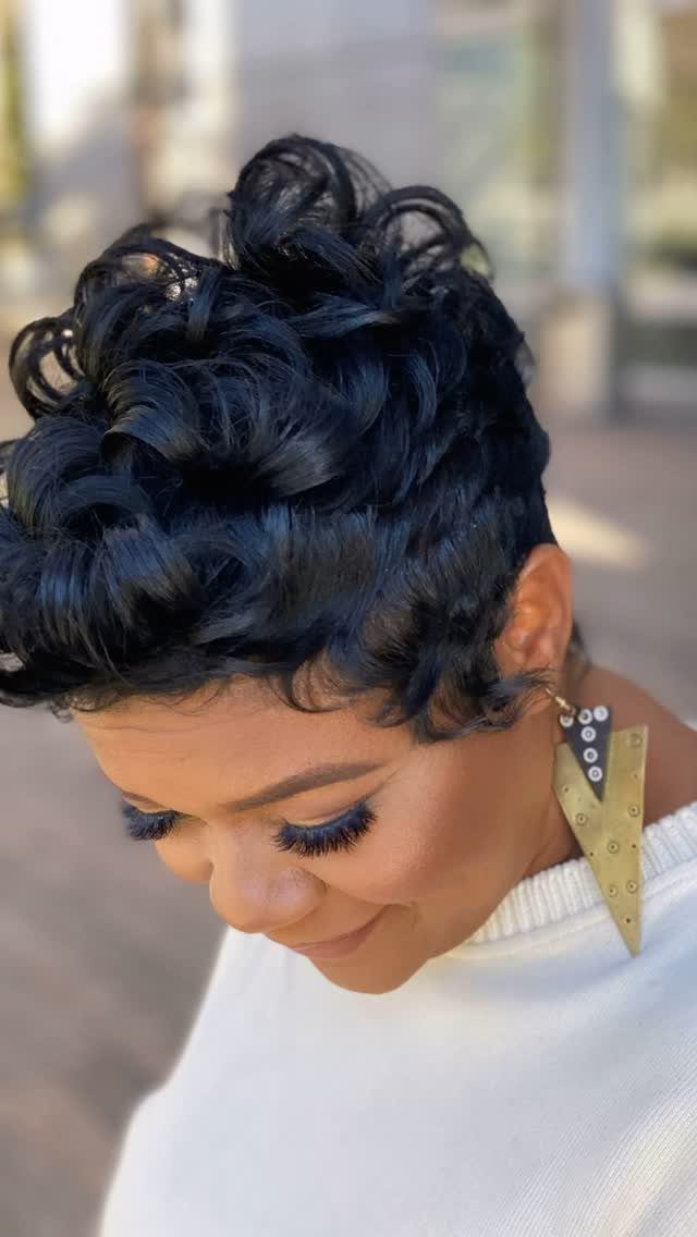 Short black curly pixie with forward-swept bangs shown from above