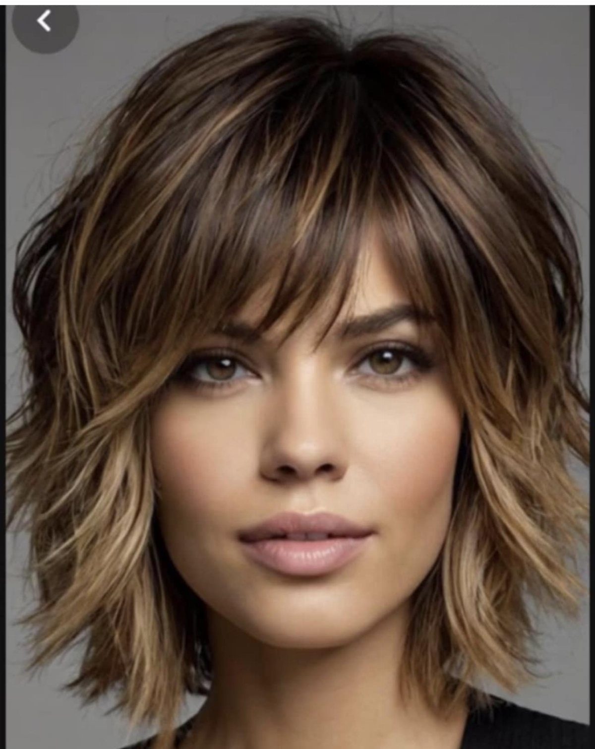 Woman with a tousled layered wavy shag haircut and forehead fringe