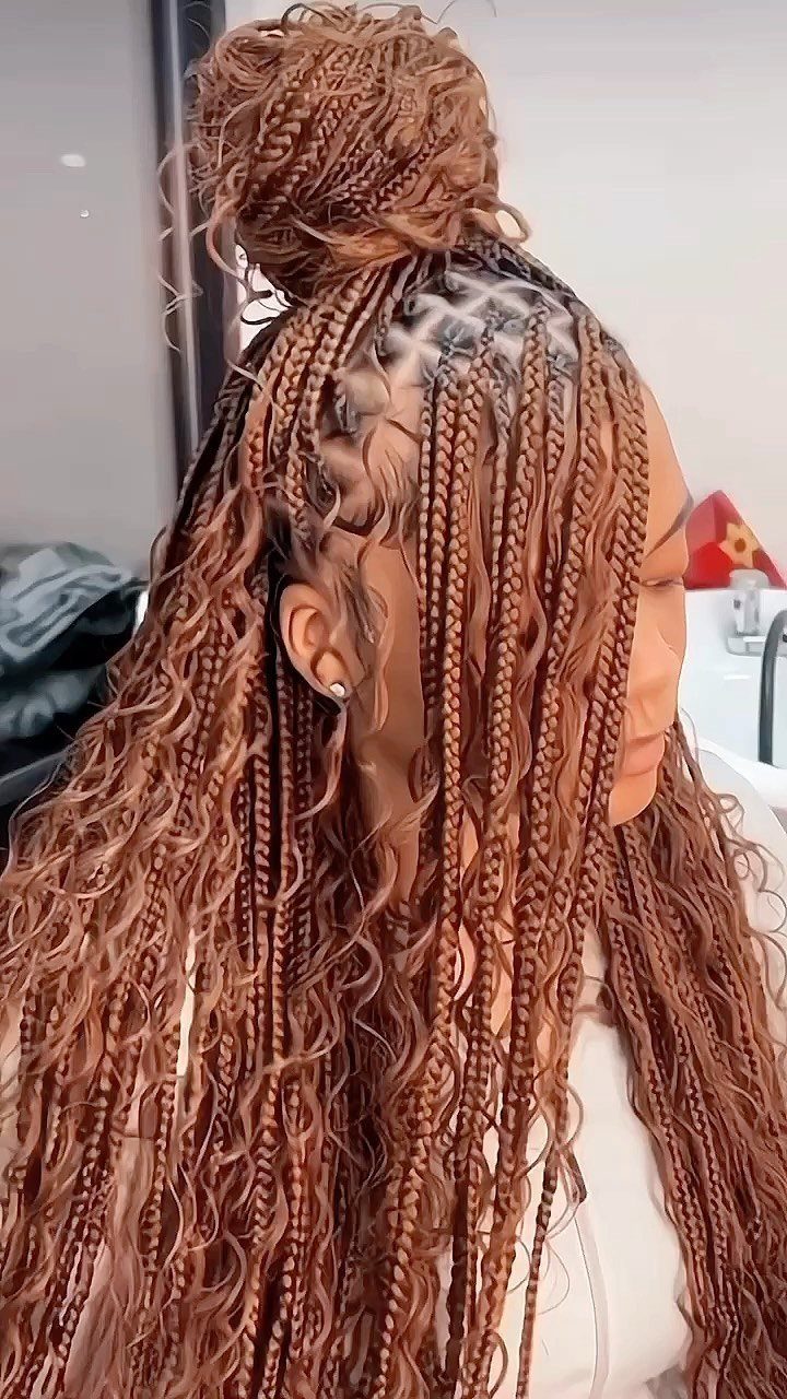 Long auburn-brown braids gathered into a high bun with loose lengths