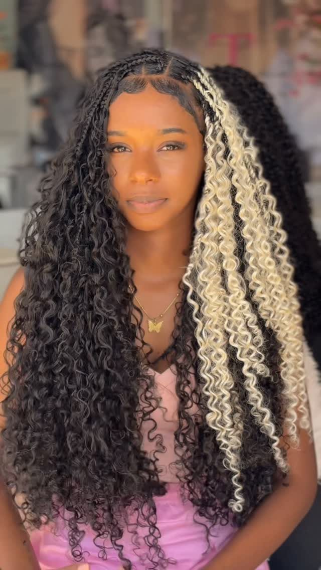 Woman wearing long dark braids with prominent pale blonde streak braids