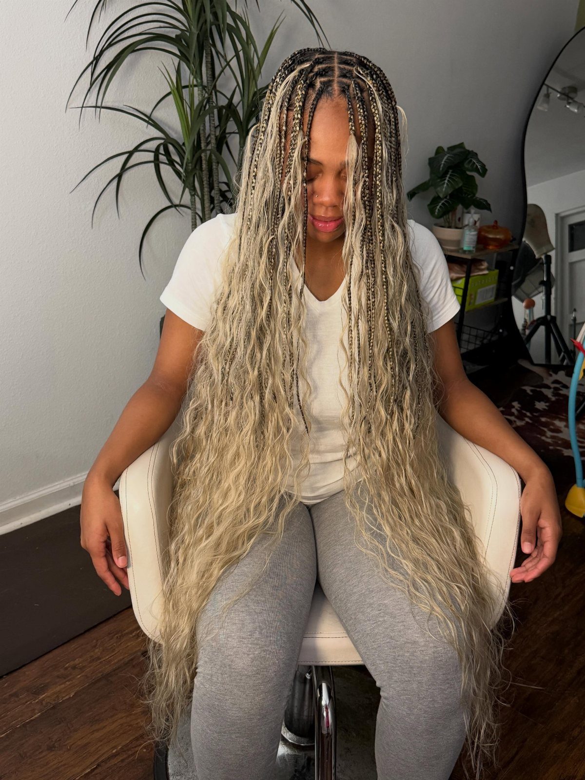 Woman displaying extremely long blonde gypsy braids with loose curls throughout