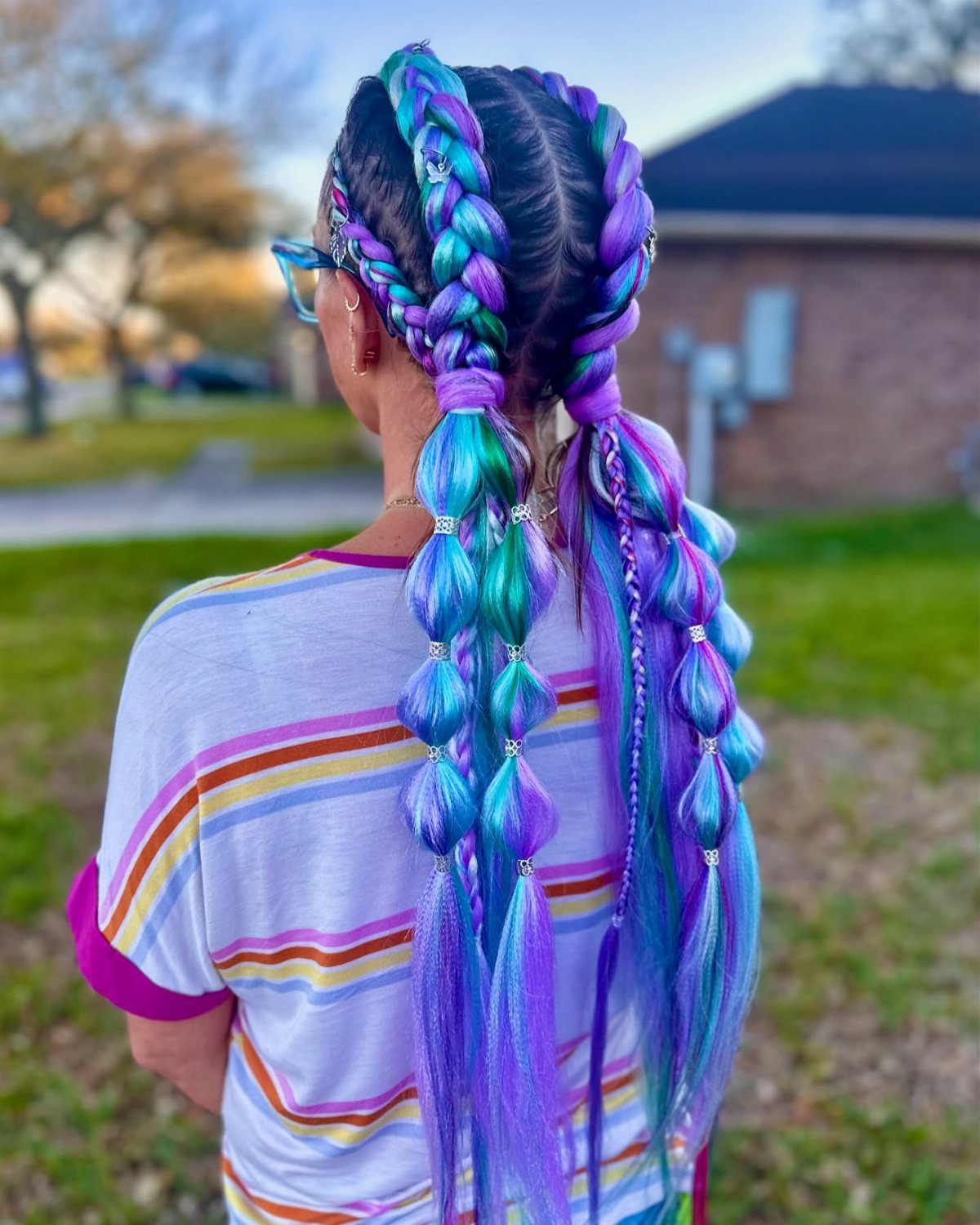 Long turquoise, blue, and purple braids with loose flowing hair