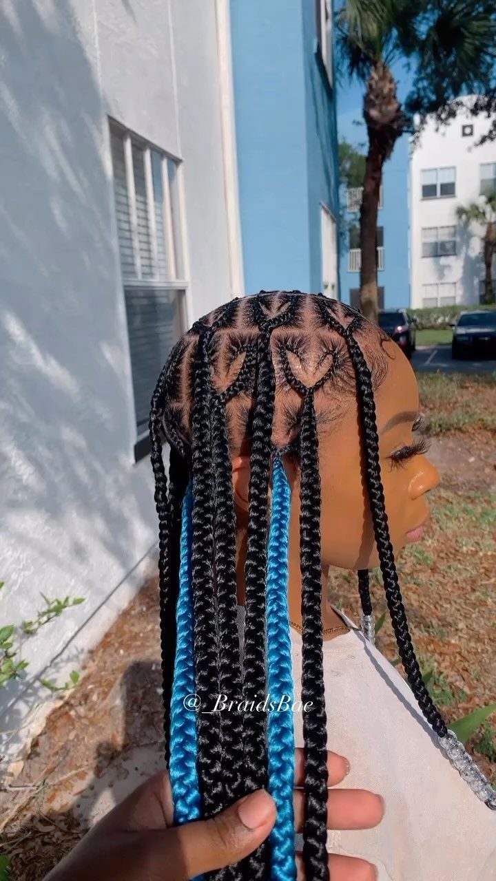 Long black braids with vivid blue peekaboo braids held beside a person's face