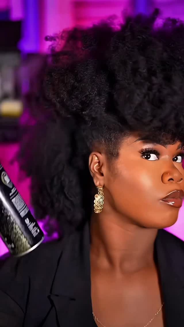 Woman posing with a voluminous curly faux hawk and closely shaped sides