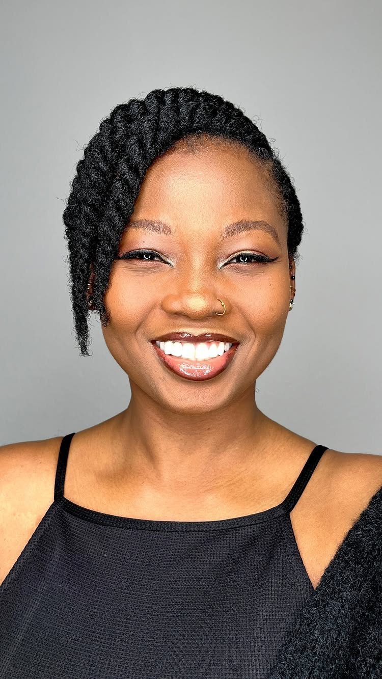 Woman smiling with natural hair styled in neat diagonal twists