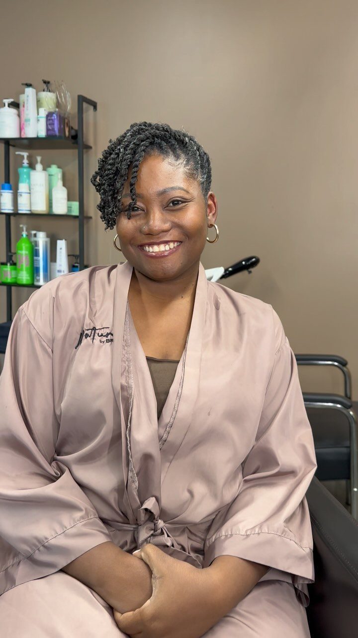 Woman in a salon with short natural twists swept across her forehead