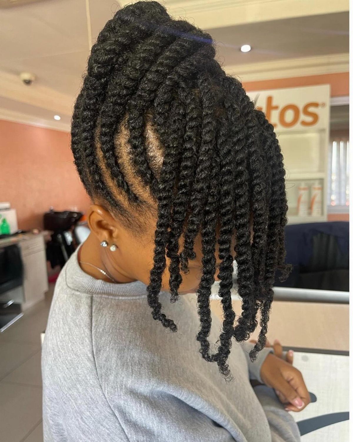 Black twists swept upward into a crown updo with hanging twists