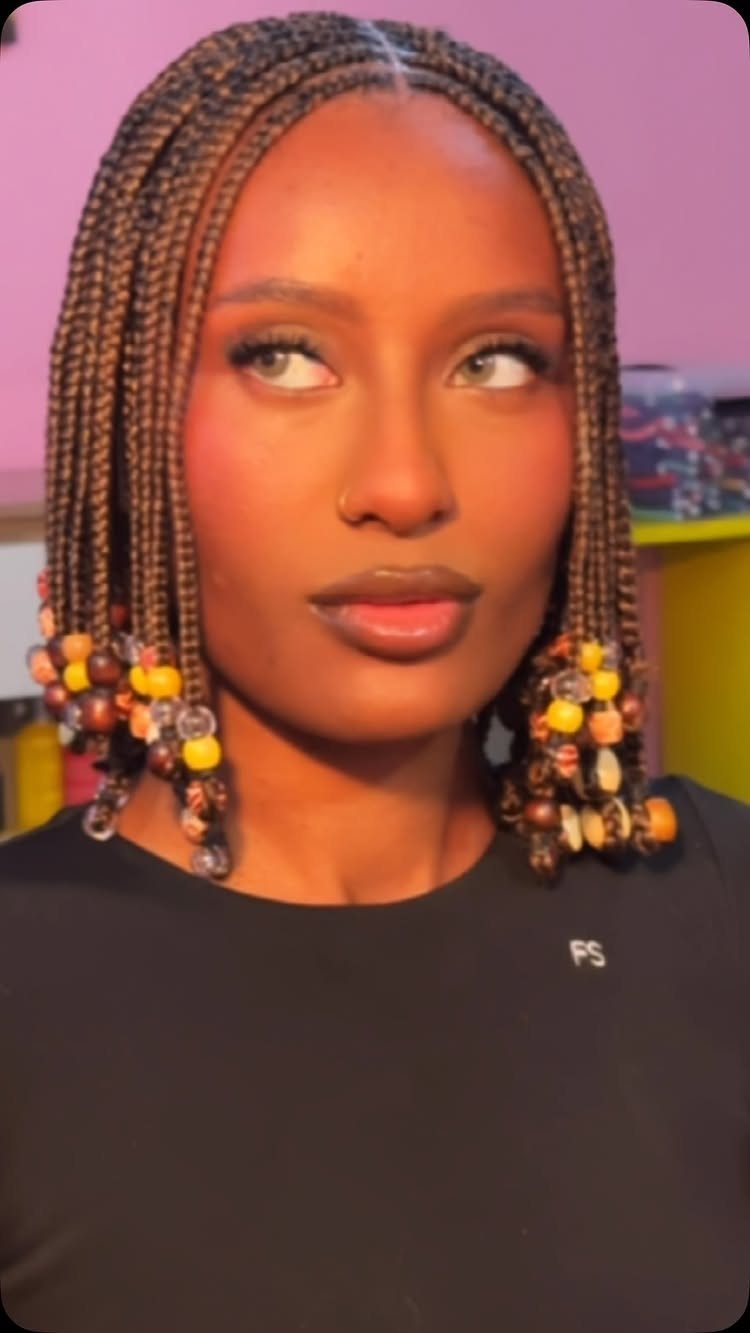 Woman wearing thin braids with colorful beads at the ends