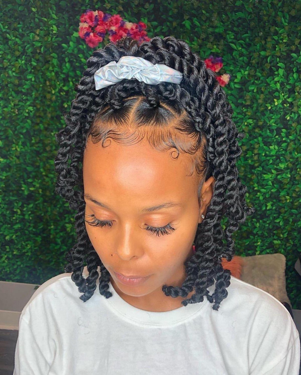 Shoulder-length twist braids styled into a bob with a pale blue bow