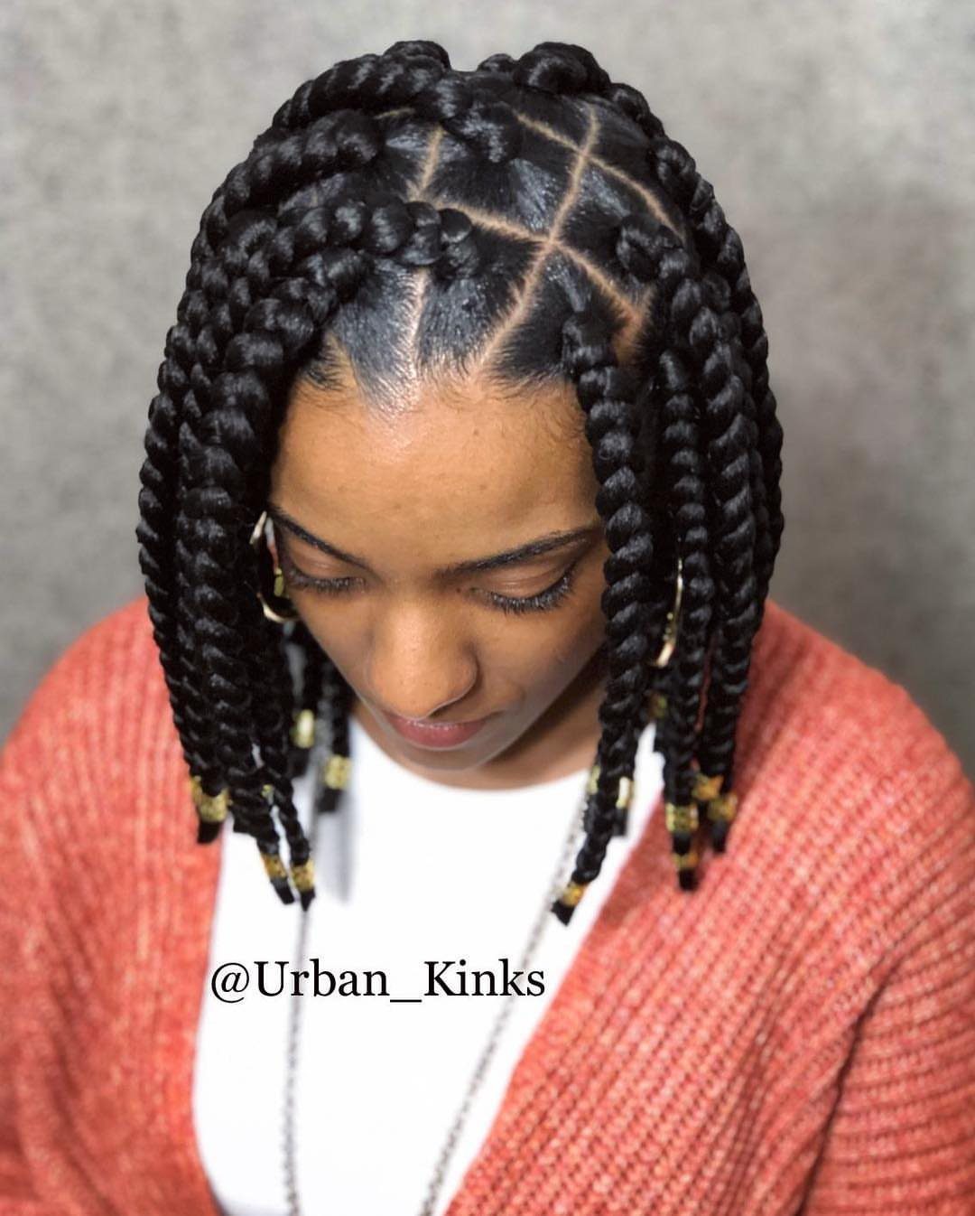 Person wearing chunky short box braids with beaded ends and precise square parting