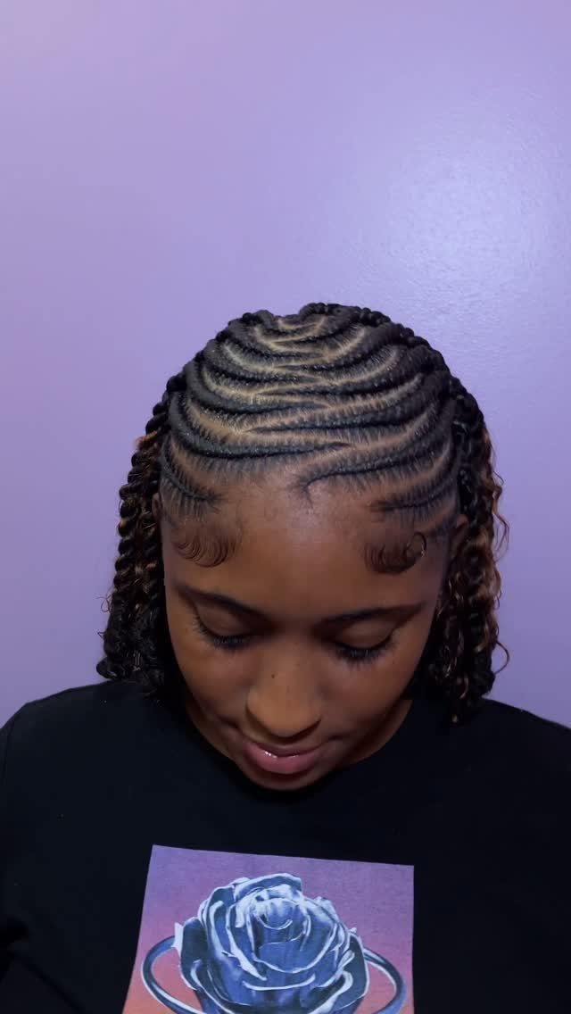 Curved cornrows meet short two-strand twists hanging beside the face