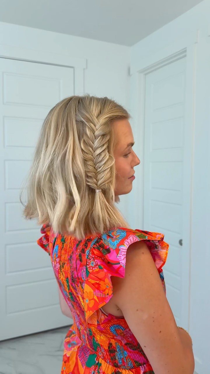 Blonde woman with a side fishtail braid and loose shoulder-length waves