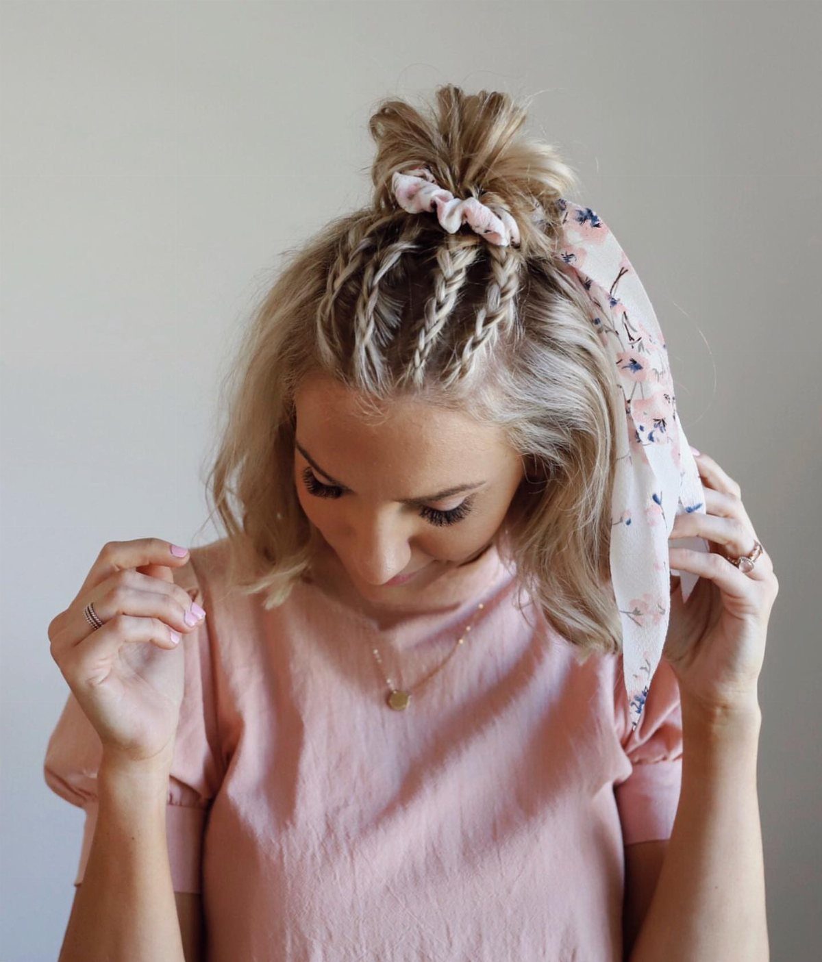 Braided half-up top knot with loose blonde hair and a floral scarf
