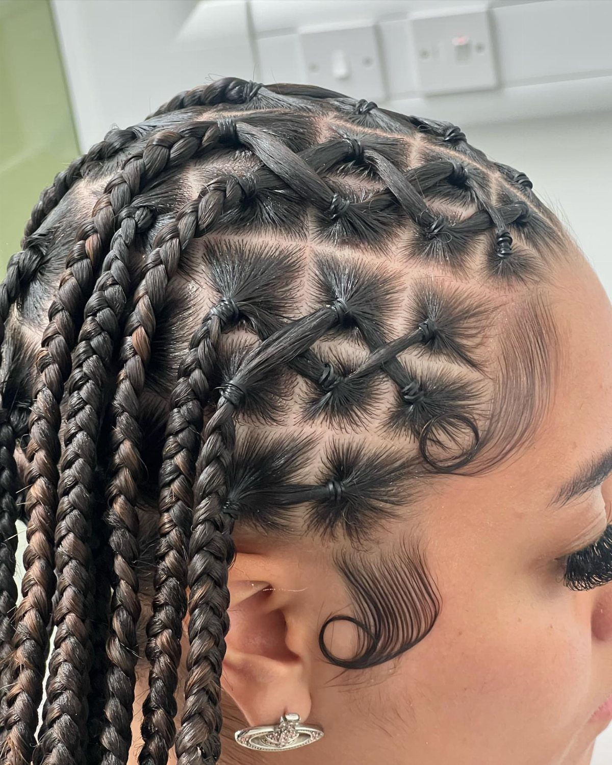 Criss-cross scalp braids combined with long hanging twists in a detailed hairstyle