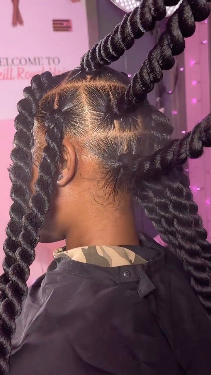 Large black twists arranged upward over neatly parted natural hair