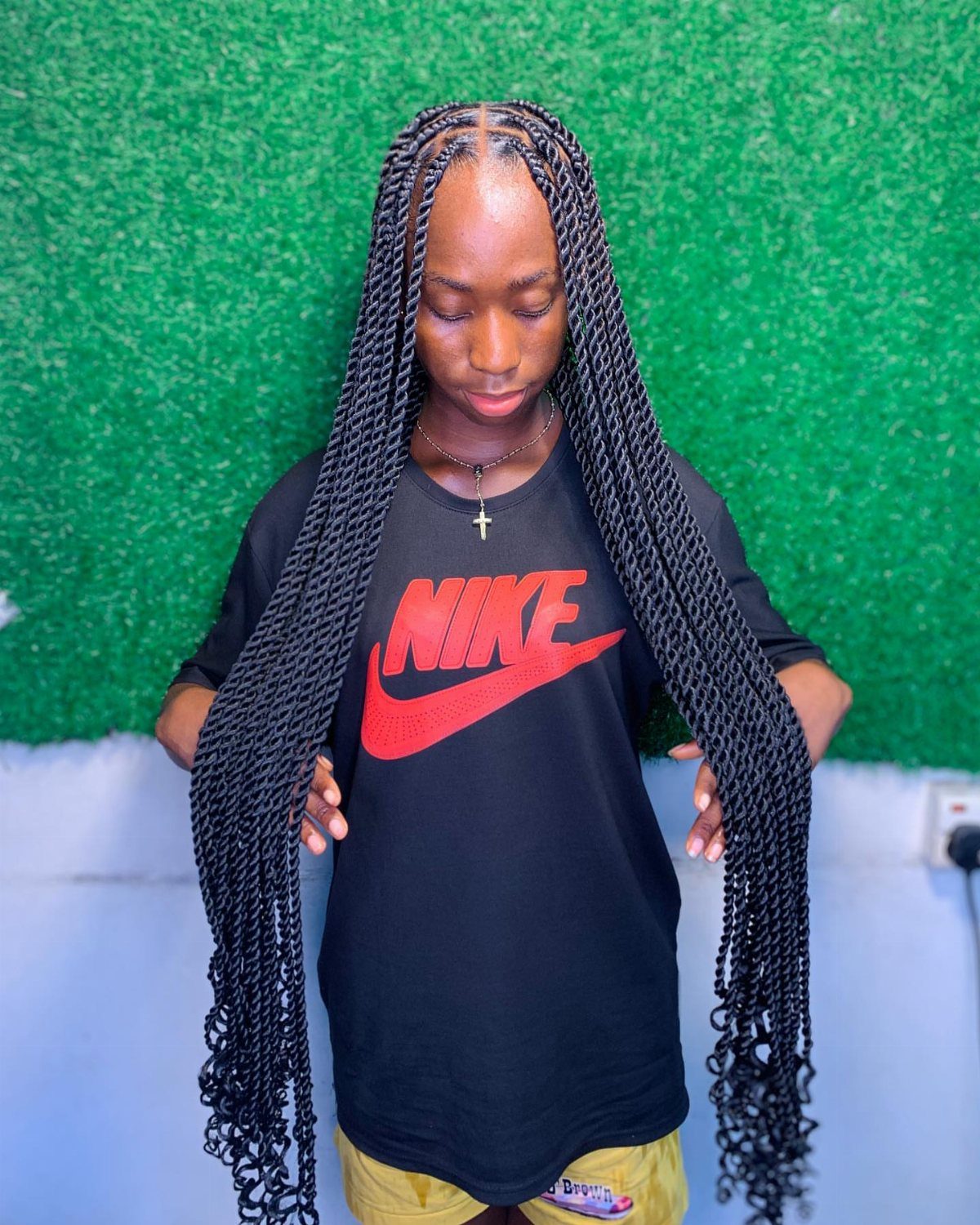 Woman displaying long center-parted twists with loose curly ends
