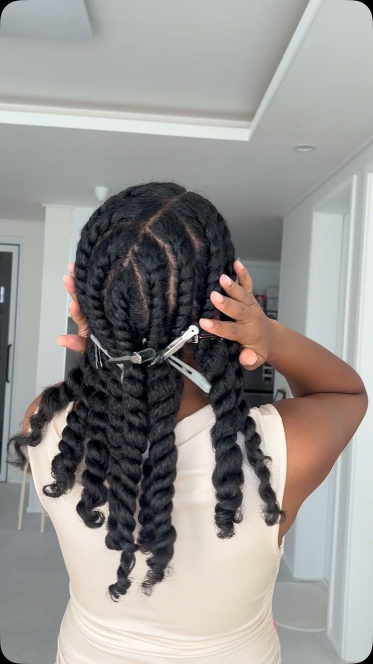 Long chunky natural twists hang down the back with curled ends
