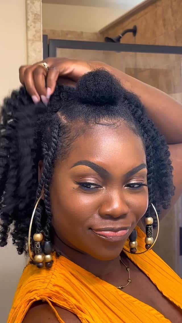 Woman wearing black Senegalese twists with loose curly ends and gold earrings