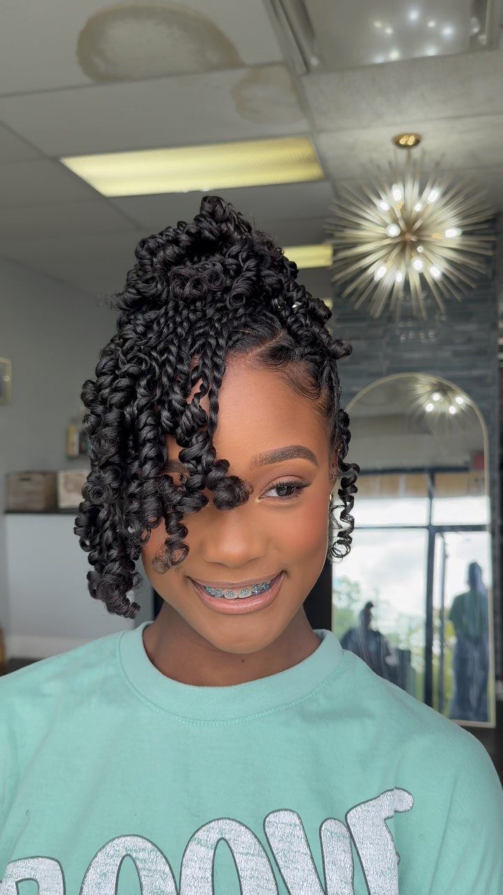 Dark twists form a voluminous crown, with loose twists framing a smiling face