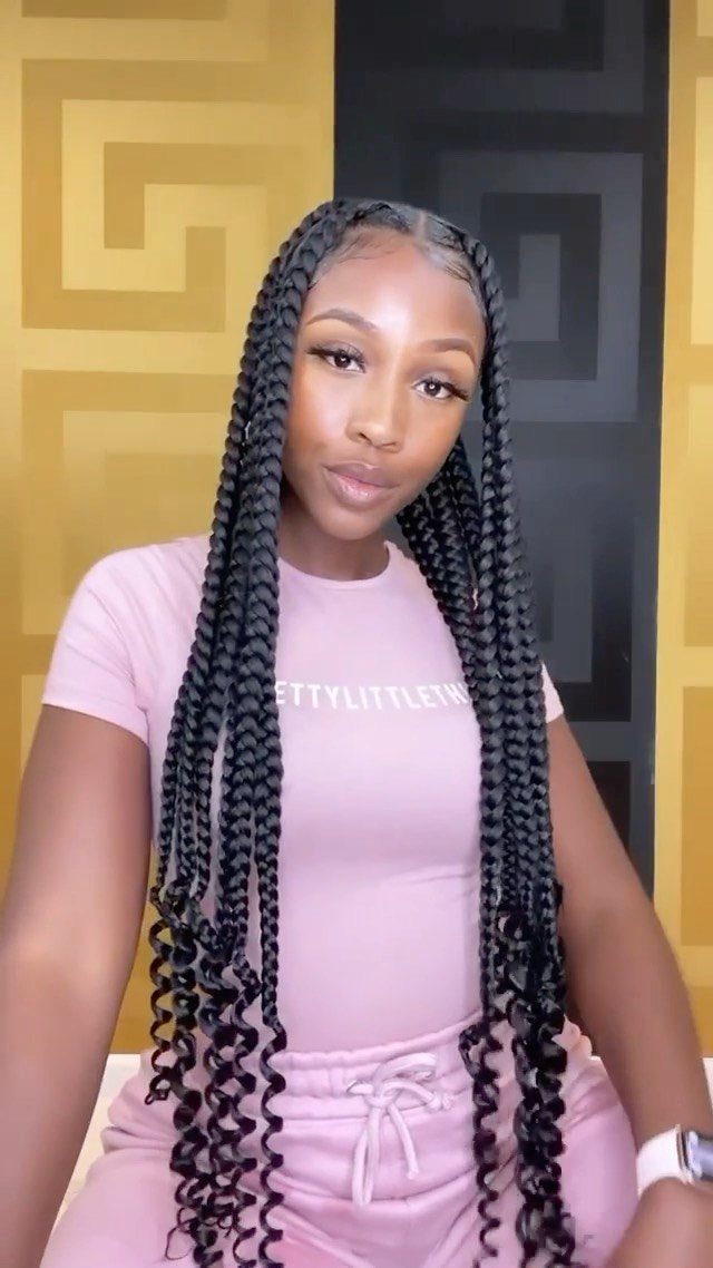 Woman wearing long black braids finished with tightly curled ends
