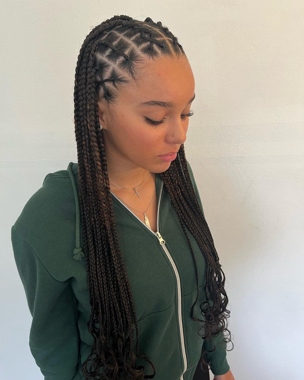 Woman wearing long criss-cross half-up box braids with curly ends