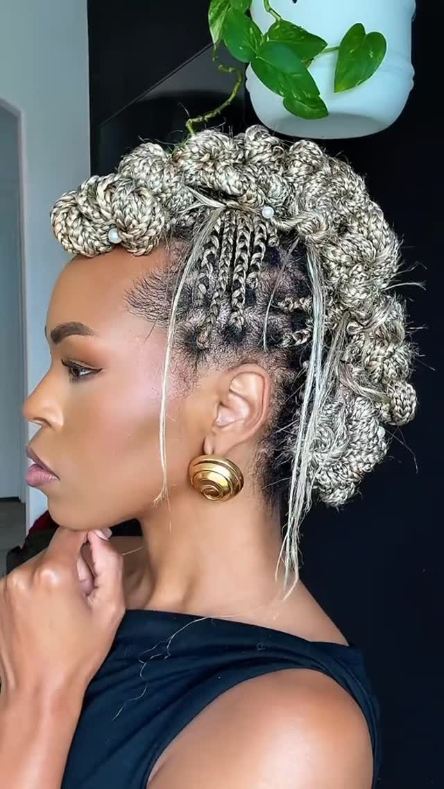 Woman wearing gray-and-black jumbo box braids styled into an elaborate updo