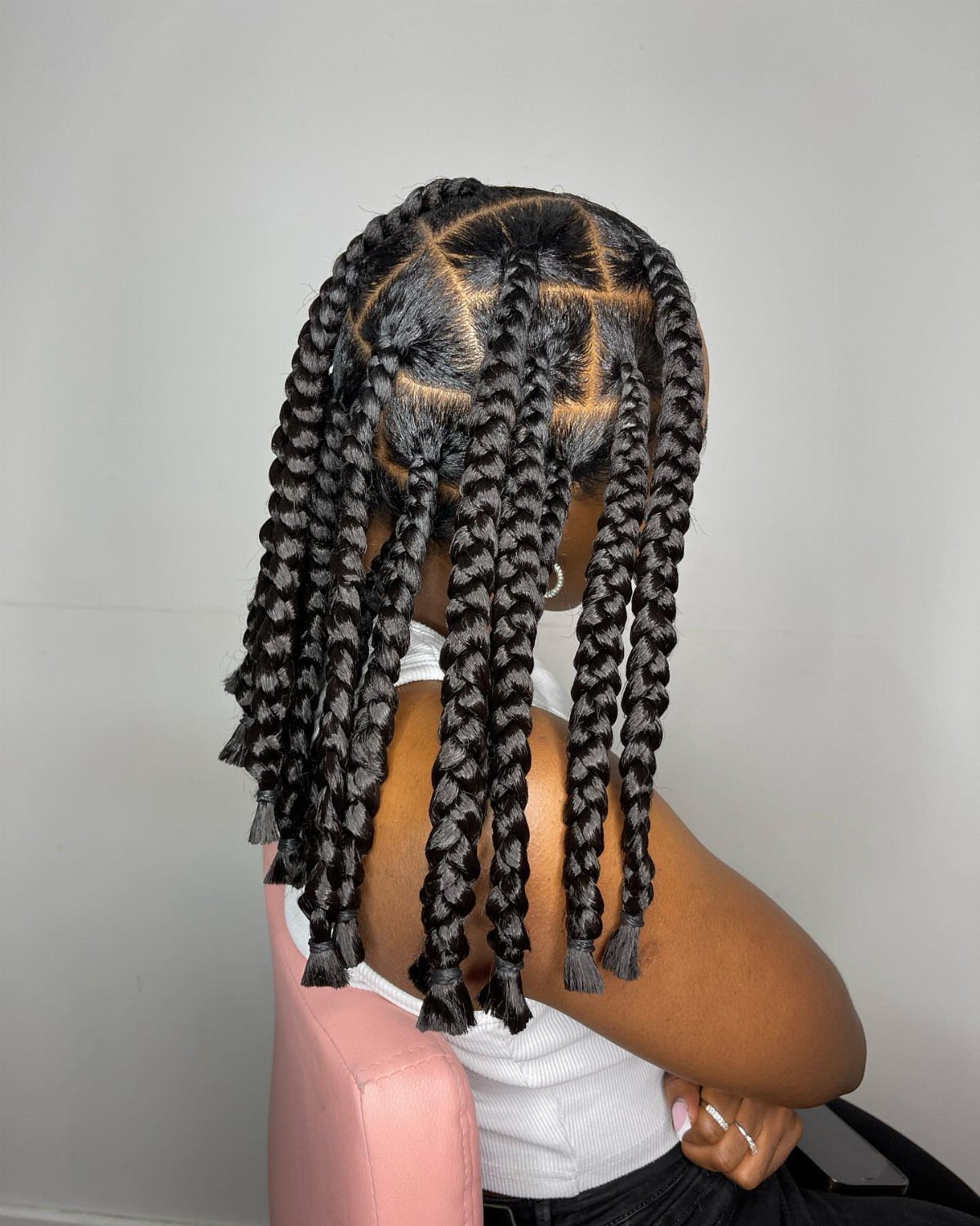 Short black jumbo box braids styled into a bob on a seated person