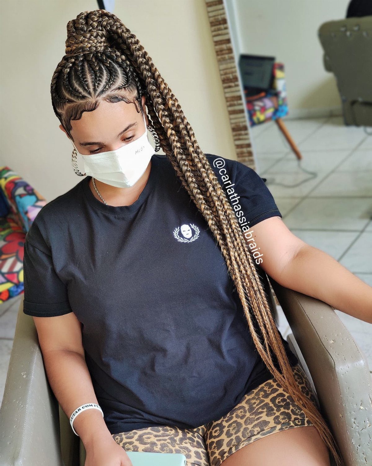 Person with long jumbo box braids gathered into a high updo