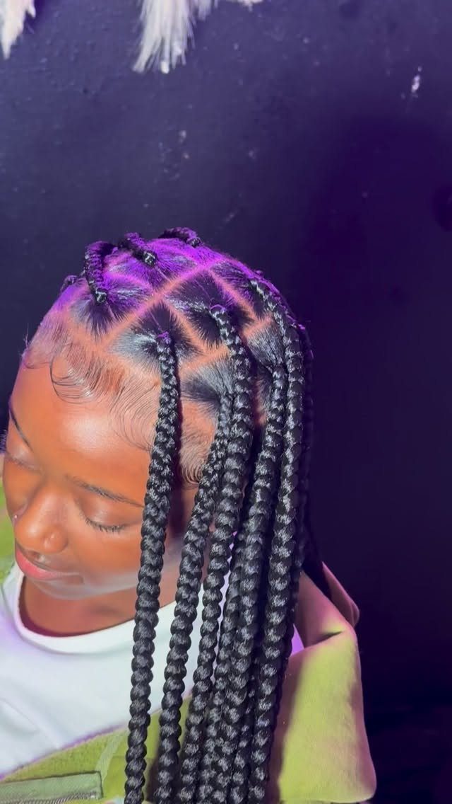 Thick black box braids hang well below the shoulders on a person