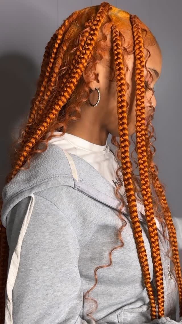 Profile view of long, thick orange-brown jumbo box braids