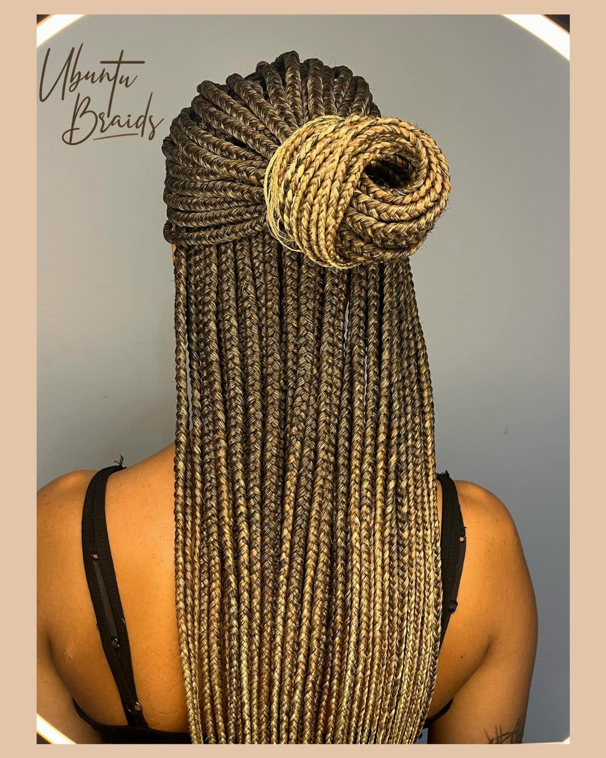 Highlighted dark braids gathered into a large bun high on the head