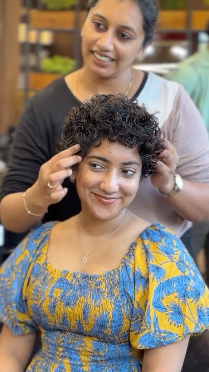 Short curly pixie haircut with longer curls on top and shorter sides