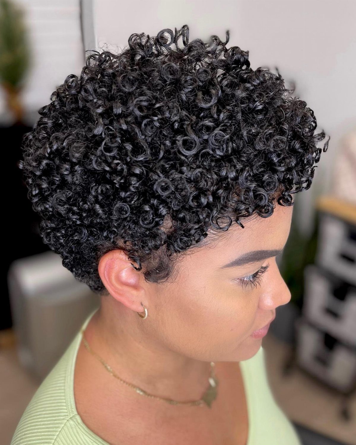 Side-profile portrait showing a dense, rounded layered afro of tightly coiled black curls