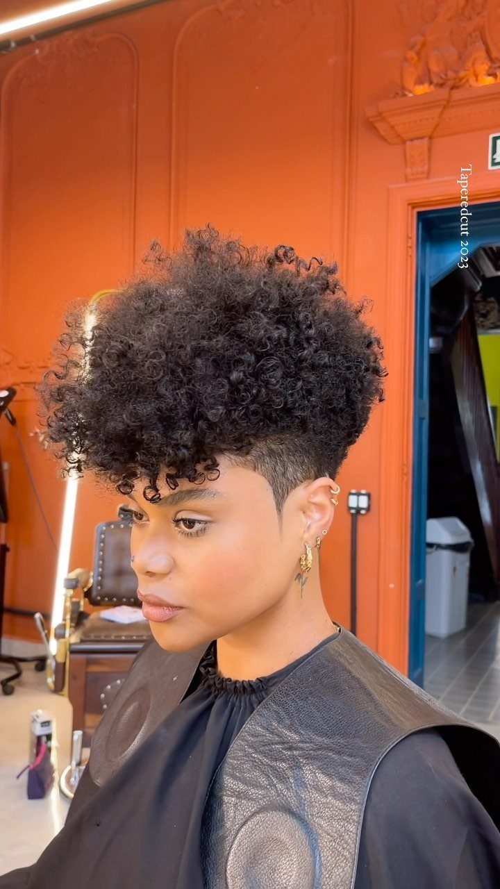 Tapered layered curls with longer volume on top and closely shortened sides