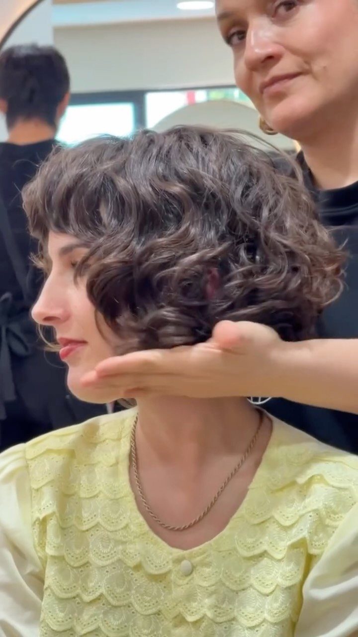 Woman showing a voluminous shaggy curly bob with short layers and bangs