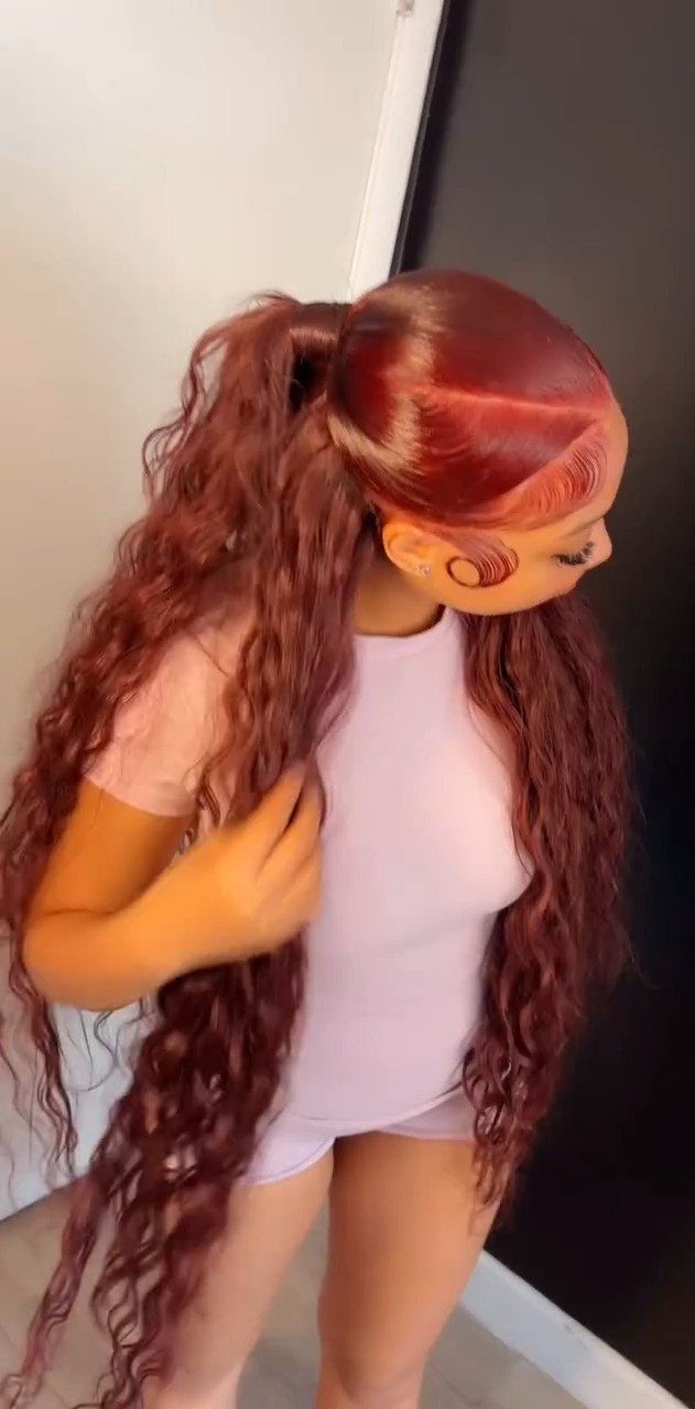 Long reddish-brown curls styled half-up with loose curls falling over the shoulders