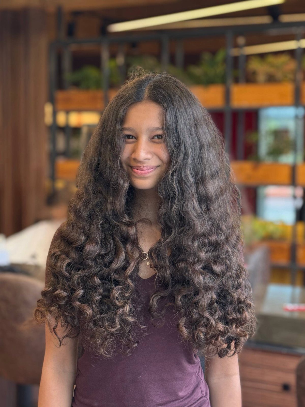 Woman with long dark curls parted centrally, falling evenly around her face