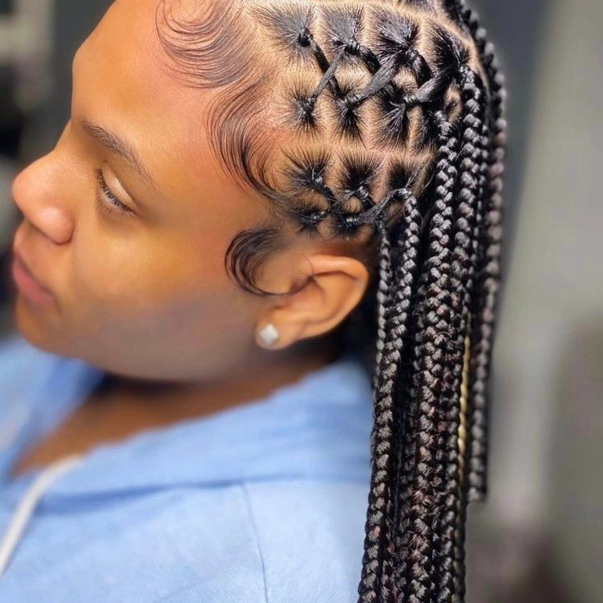 Black box braids cross over at the scalp, with long braids and styled baby hairs