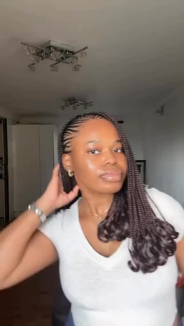 Woman wearing long dark box braids with curled ends over one shoulder