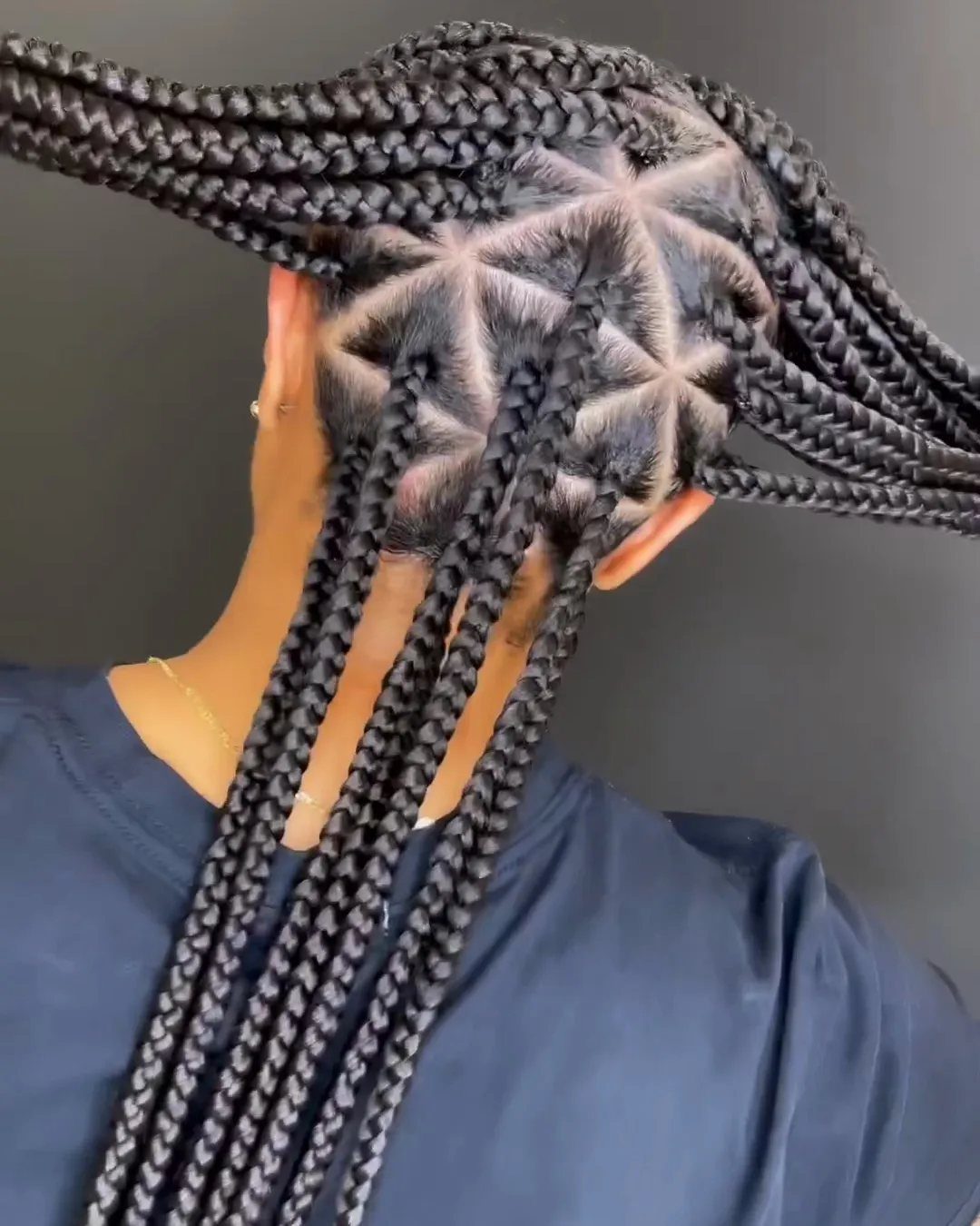 Black box braids arranged in triangular sections, with long straight braided ends