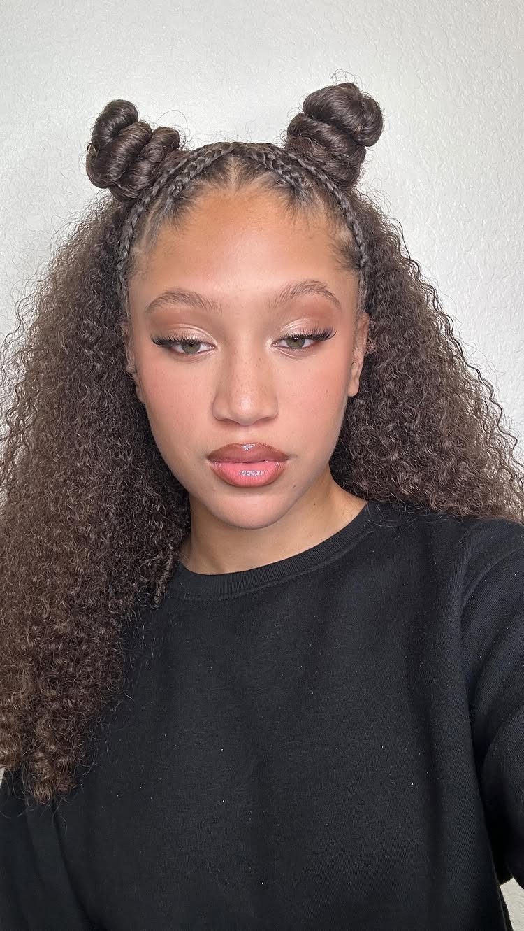Woman wearing two braided buns with long curls hanging loose