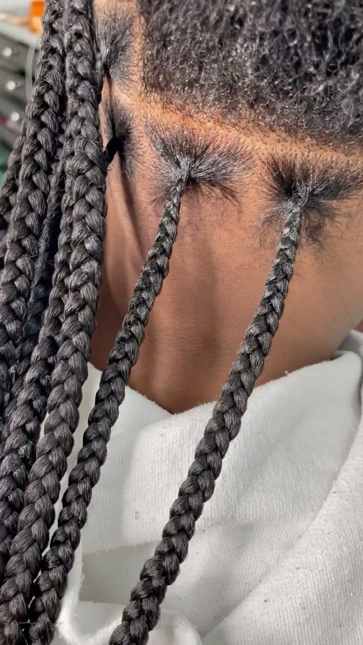 Flat black knotless braids start neatly along a person's hairline
