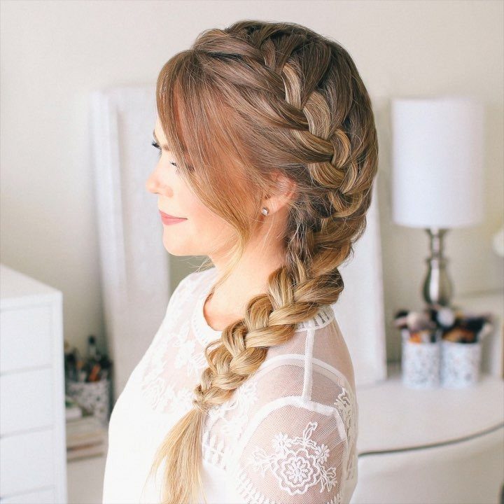Woman wearing a thick side-swept French braid over one shoulder