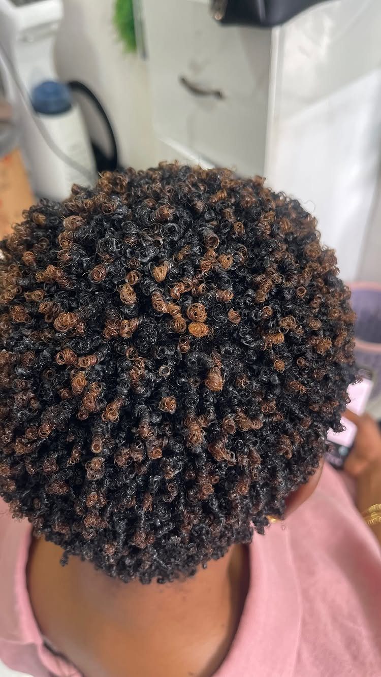Defined finger-coiled natural curls viewed from above in a salon chair