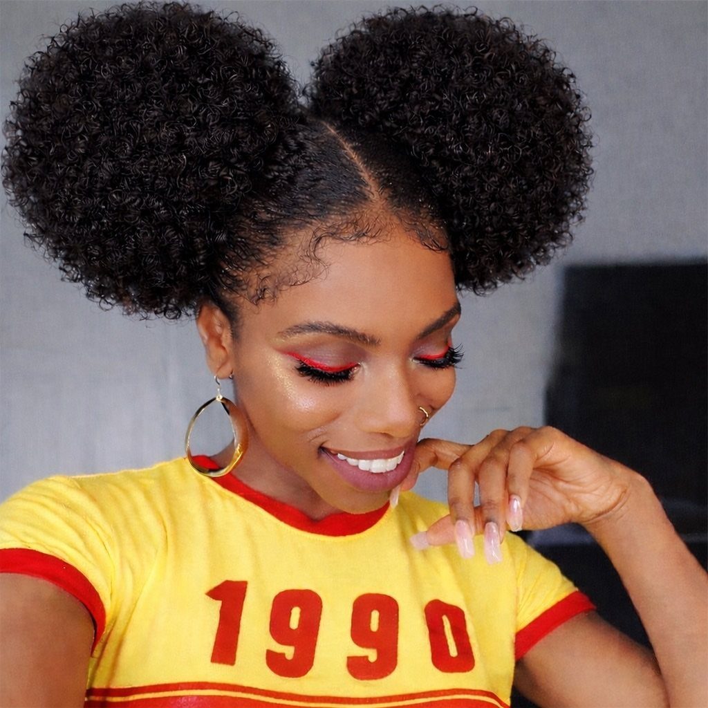 Woman wearing two slicked-back natural curly puff buns with a center part